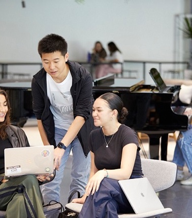 IE students speaking an looking at a a computer