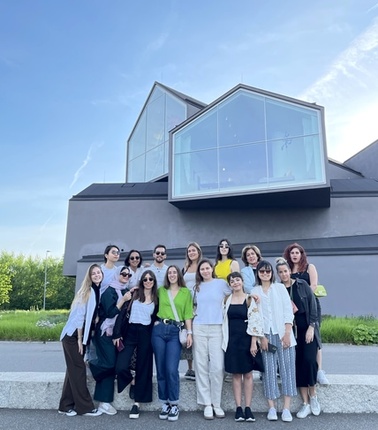 a group of architecture students possing for the camera in front of a modern building