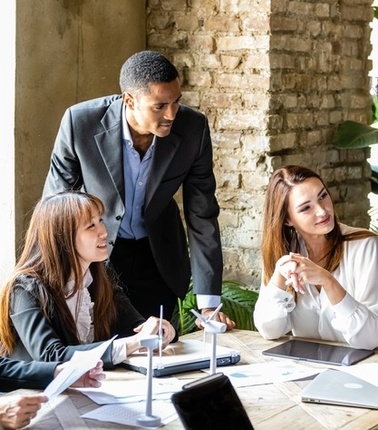 A diverse group of professionals engaged in a meeting around a table.