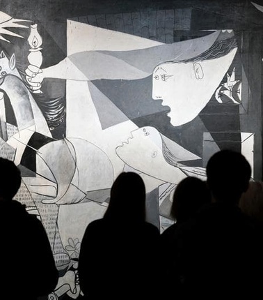 A group of people observing a striking black and white artwork featuring distorted figures and chaotic elements.
