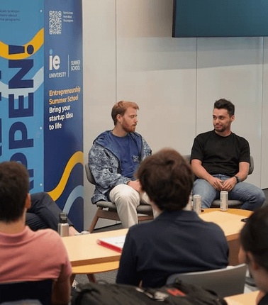 A group of three speakers participating in a discussion at an entrepreneurship event.