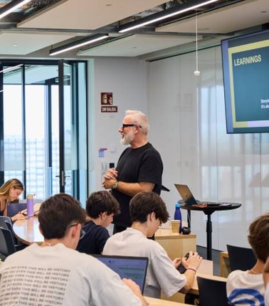 A teacher is instructing a group of students in a modern classroom.