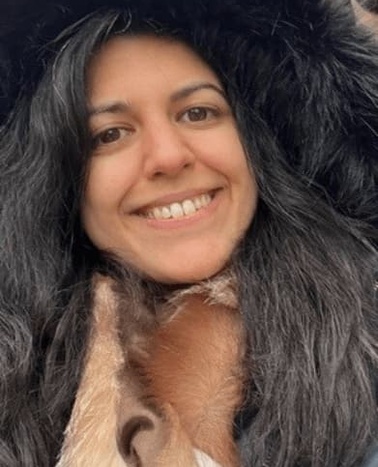 A smiling woman wearing a fur hooded coat.
