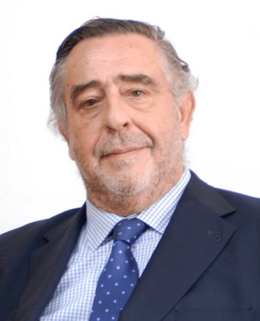 Portrait of an elderly man in a suit and tie with a light blue shirt and a polka-dot tie.
