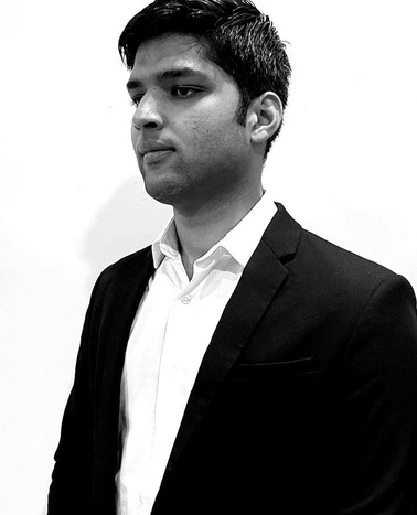 A black and white photo of a young man in a suit looking to the side.