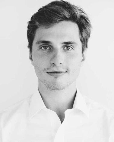 Black and white portrait of a young man wearing a white shirt.
