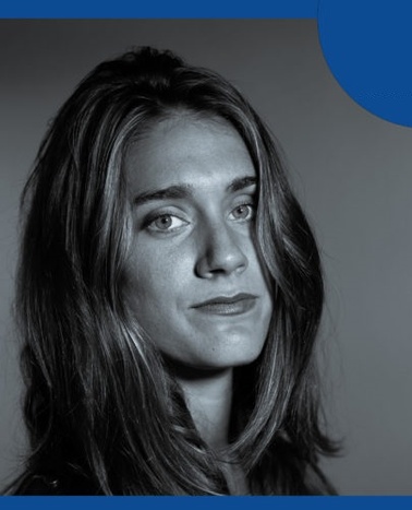 Portrait of a young woman with long hair, featuring a serious expression, set against a plain background.