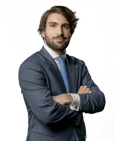 A professional man in a suit standing with his arms crossed.