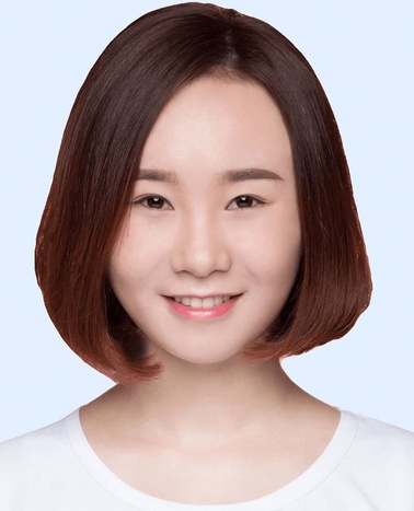 A portrait of a young woman with shoulder-length brown hair and a gentle smile, against a light blue background.