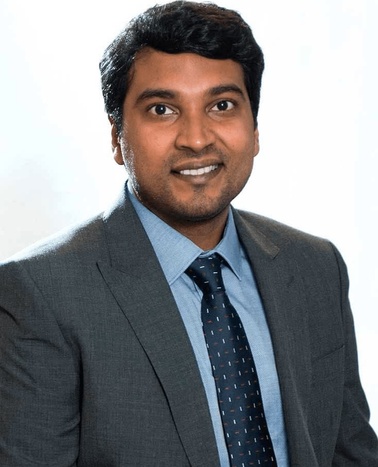 A portrait of a smiling man wearing a suit and tie.