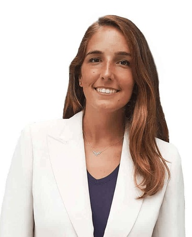A professional portrait of a smiling woman wearing a white blazer over a purple top.