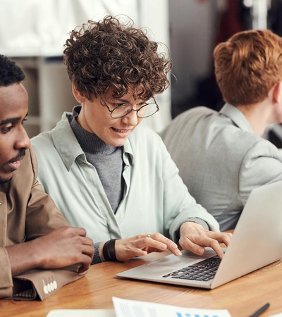 A group of people engaged in a collaborative work environment around a table.