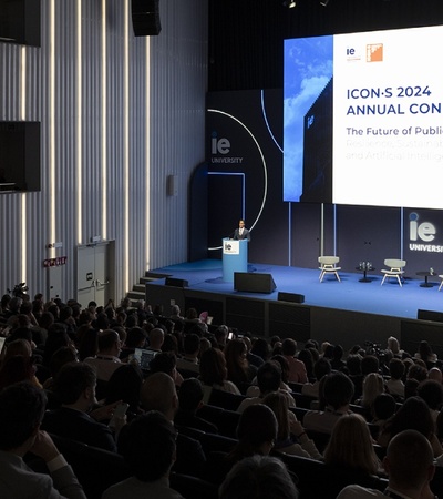 An audience attentively listens at the ICONS 2024 Annual Conference on the future of public law, held in a modern auditorium.