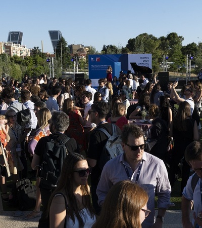 A large group of people gathered outdoors at a social event, possibly a festival or conference, with some wearing business attire.