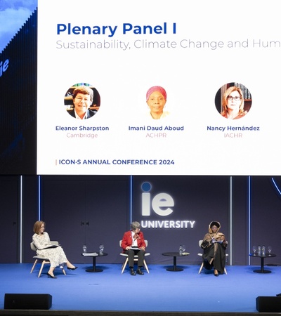 A panel discussion at the ICONS Annual Conference 2024 on sustainability, climate change, and human rights, featuring four speakers seated on stage with their names and topics displayed above.