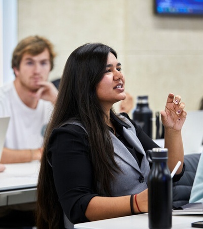 A young woman actively participating in a classroom discussion.