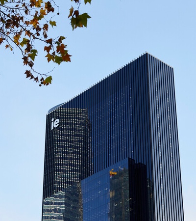 A modern skyscraper with the letters 'ie' visible on its facade against a clear blue sky.