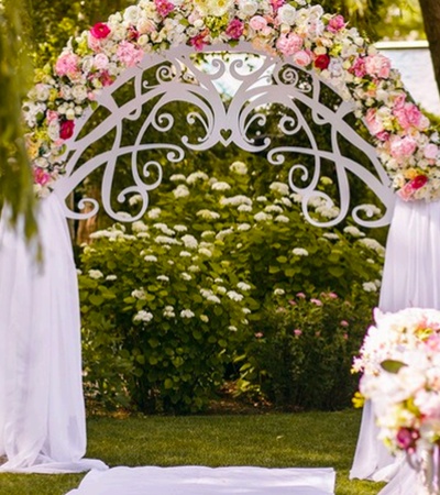 A beautiful floral wedding arch setup in a garden.