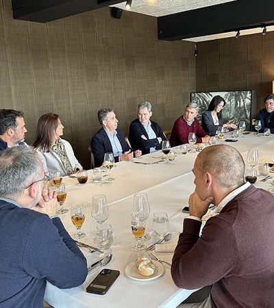 A group of people engaged in a discussion around a dining table.