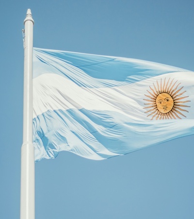 The Argentine flag waving under a clear blue sky.