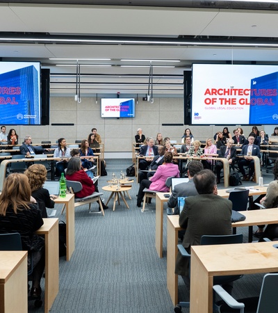 A conference room filled with people attending a meeting about global architecture.