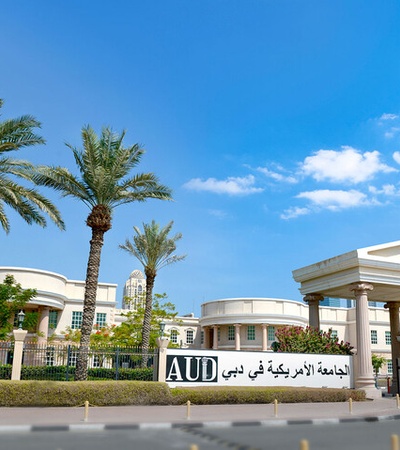 A beautiful university campus with palm trees and clear blue skies.