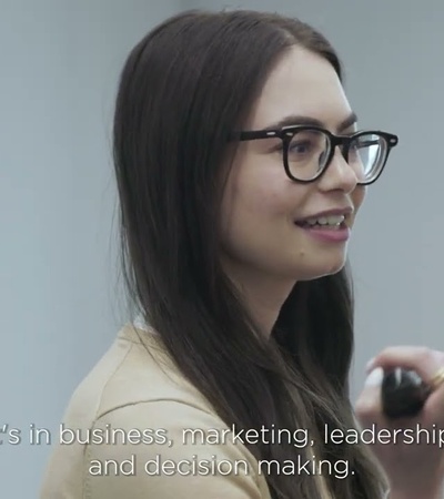A woman with glasses is explaining concepts related to business and leadership.