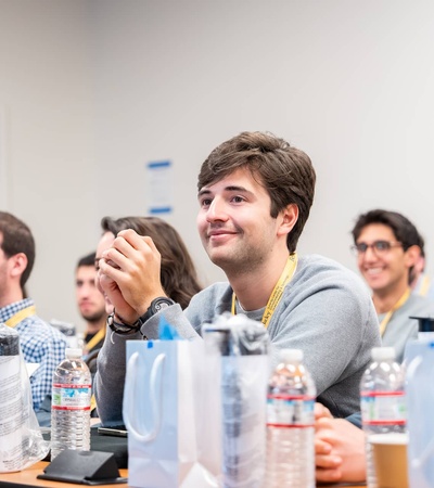 Group of people sitting in a classroom, listening attentively.