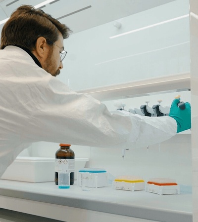 A scientist in a lab coat is working at a laboratory bench with various equipment.