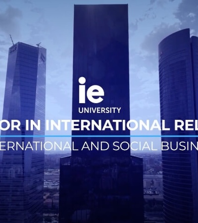 An advertisement for IE University's Bachelor in International Relations, set against a backdrop of skyscrapers.