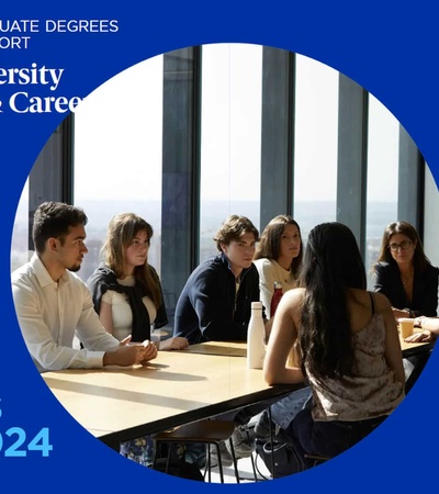 A group of students is sitting around a table engaged in discussion at a university.