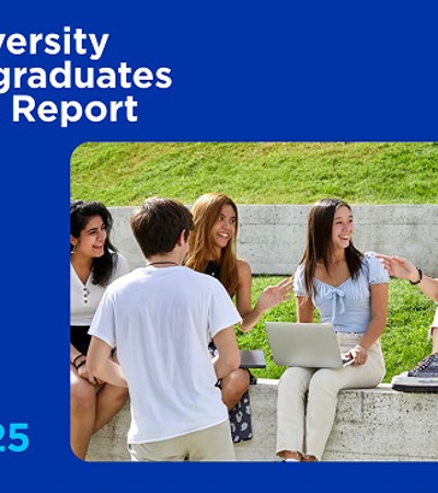 A group of students is engaged in discussion on a campus outdoors.