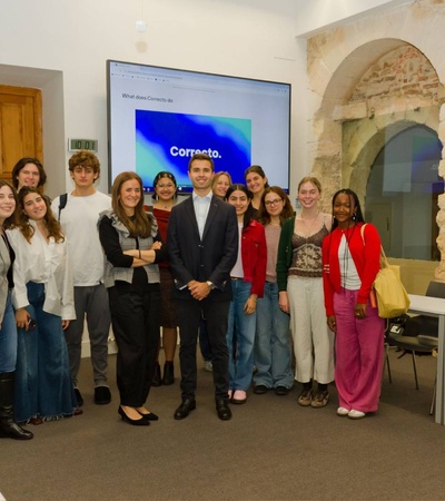 A group of young adults posing together in a modern conference room.