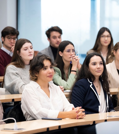 A group of students attentively listening in a classroom setting.