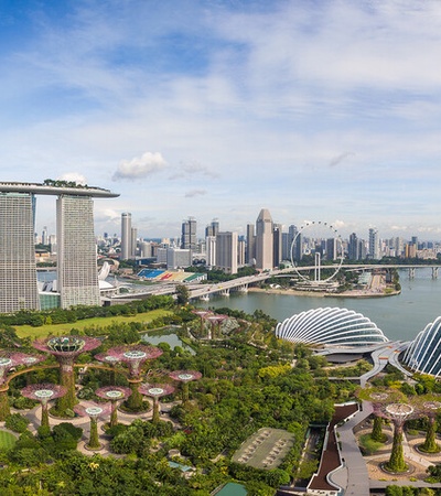 Aerial view of Marina Bay in Singapore showing the iconic Marina Bay Sands, the ArtScience Museum, and the Supertree Grove at Gardens by the Bay.