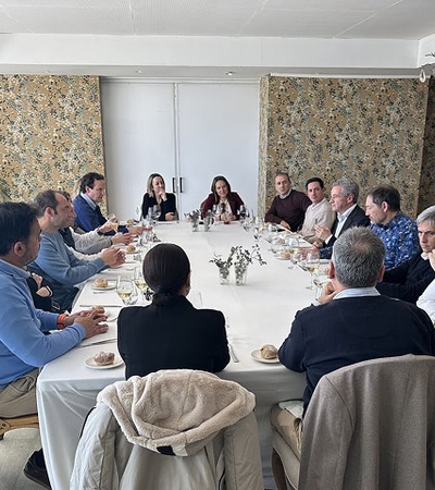 A group of people sitting around a table during a meeting or gathering.
