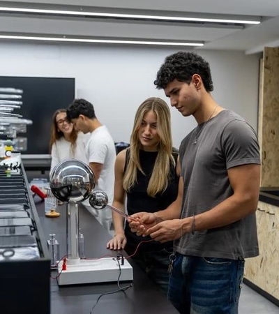 A group of young people are engaged in an interactive science experiment in a modern classroom.