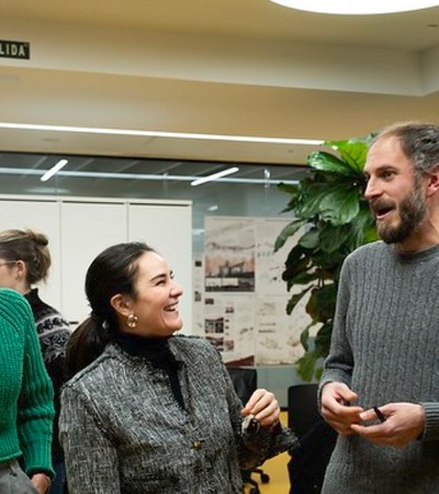 Group of people engaging in conversation indoors at an event.