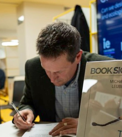 A man signing a book at a book signing event