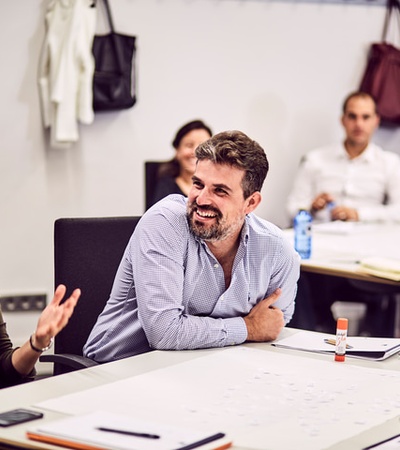 A group of people in a meeting are engaged in a lively discussion.