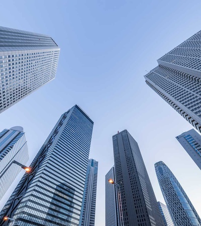 A view looking up at tall skyscrapers against a clear sky.