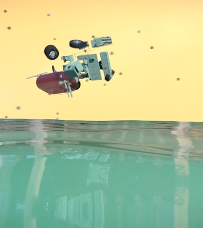 A submerged vehicle partially emerging from water against a pastel-colored sky.