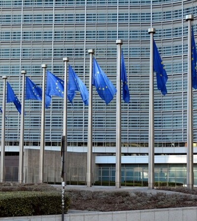 A modern building with numerous blue flags in front of it.