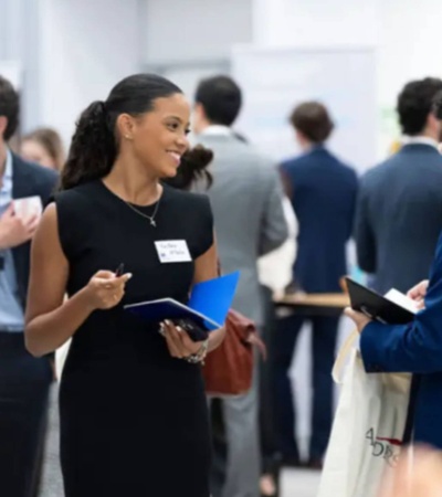 A professional woman is engaging in conversation at a networking event.