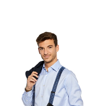 A young man in a blue shirt with suspenders holding a jacket over his shoulder.