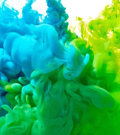 A vibrant image of blue and green ink swirling in water.