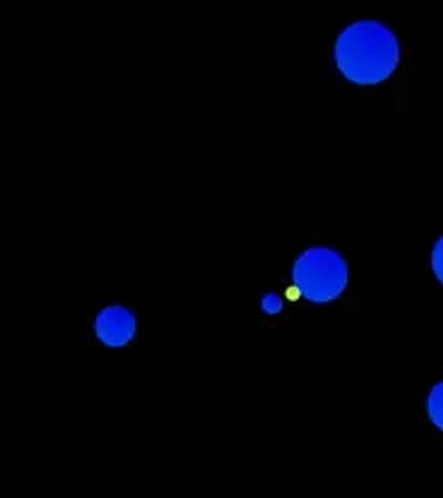 An abstract image of glowing blue and green dots scattered across a black background.