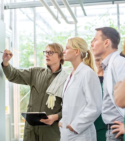 A group of professionals discussing a display screen in a modern workspace.