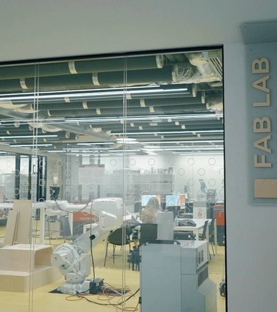 A modern Fab Lab workspace featuring various machines and workstations.