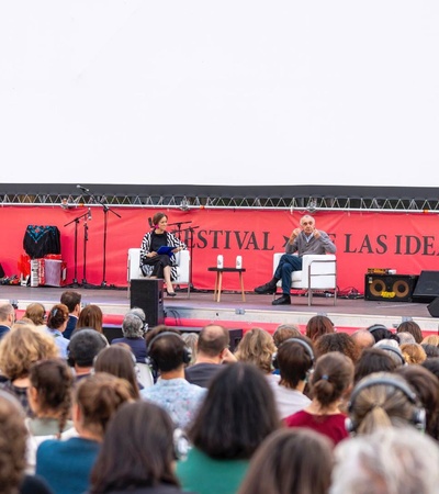 A public discussion at a festival featuring two speakers on stage in front of an audience.